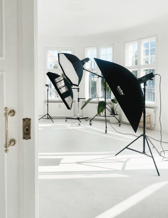 Helles Fotostudio mit großen Fenstern, ausgestattet mit professionellen Godox-Softboxen und moderner Beleuchtungstechnik.