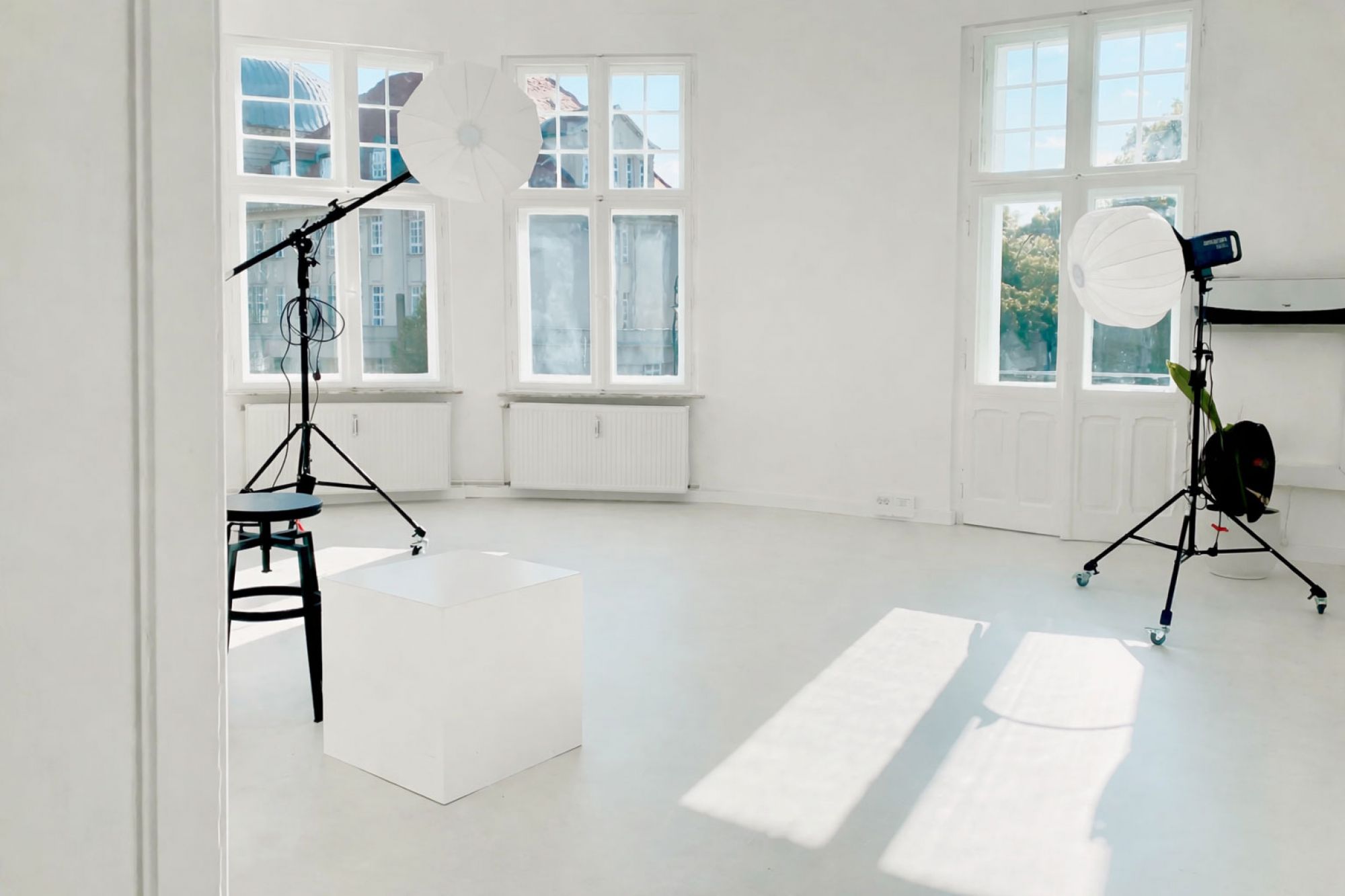 Helles Fotostudio mit großen Fenstern, ausgestattet mit professionellen Softboxen und modernem Equipment für kreative Projekte.
